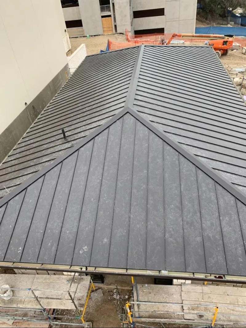 Commercial metal roof construction with crane equipment in Plainfield